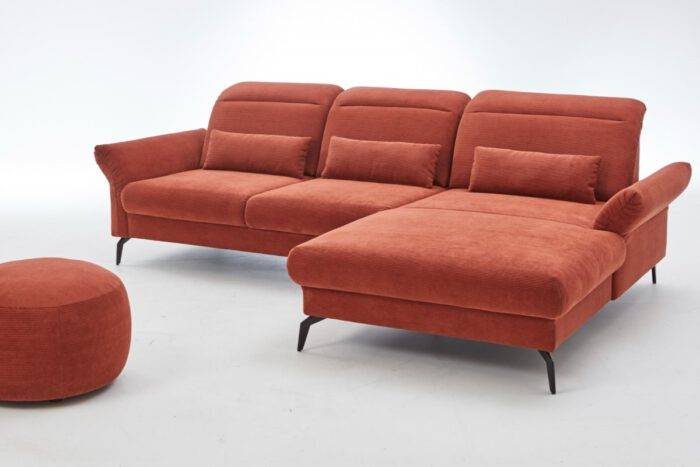 Rotes Cordsofa mit Einzug im Rücken und schwarzen Metallfüßen